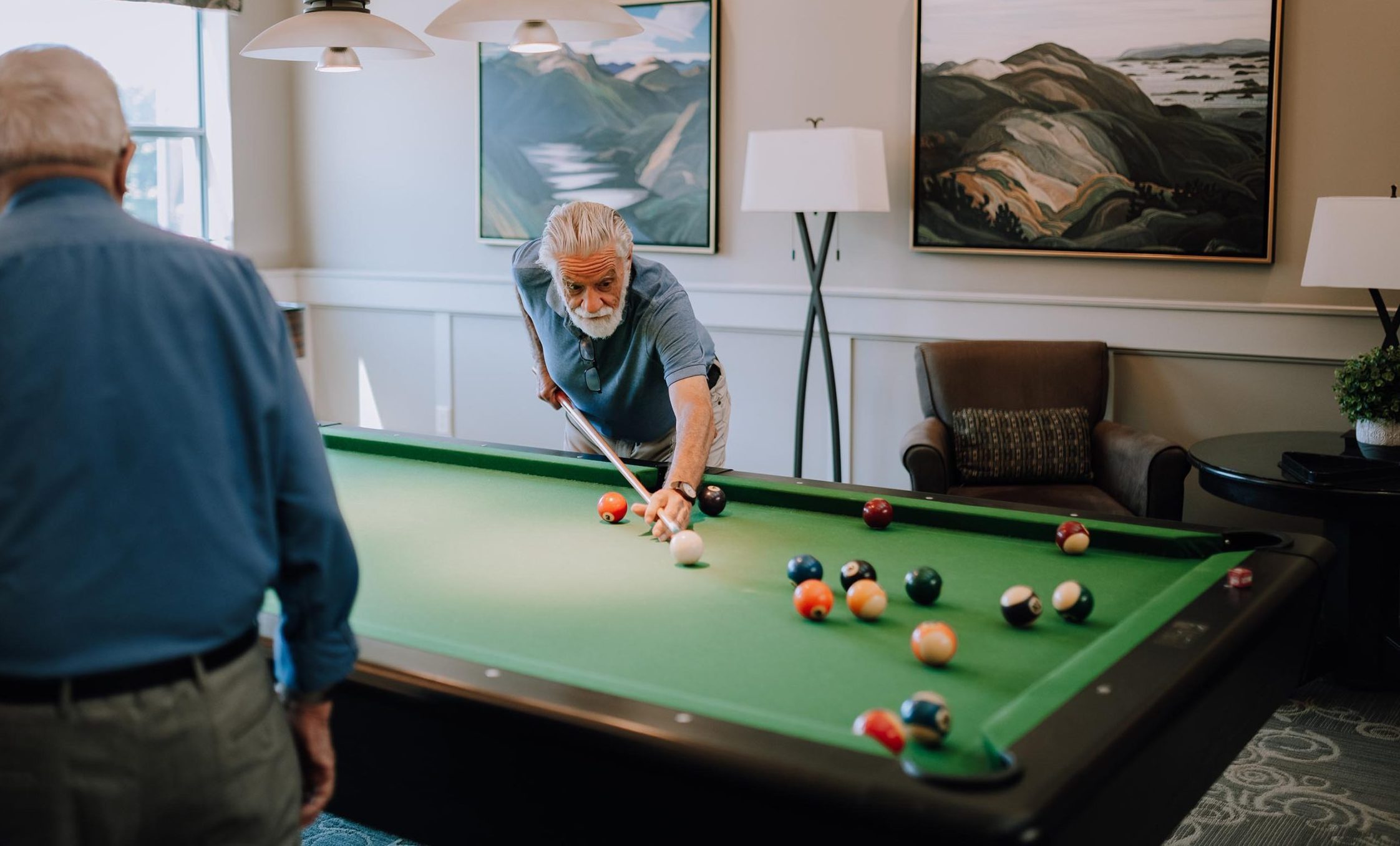 Two senior men play pool at retirement home in Nanaimo